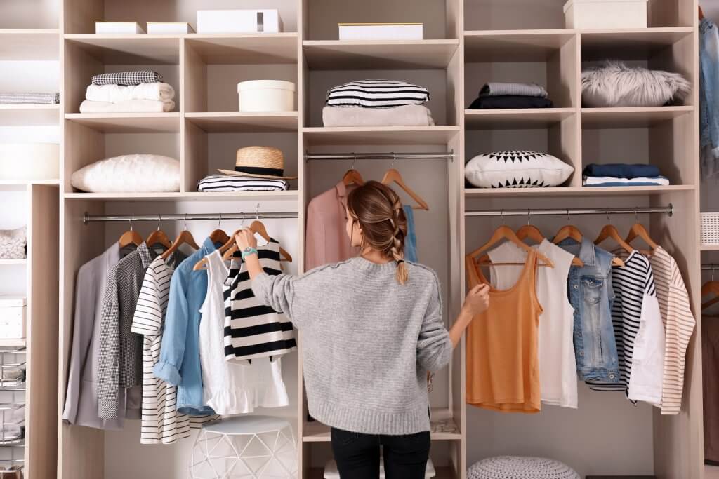 woman looking at clothes in her closet
