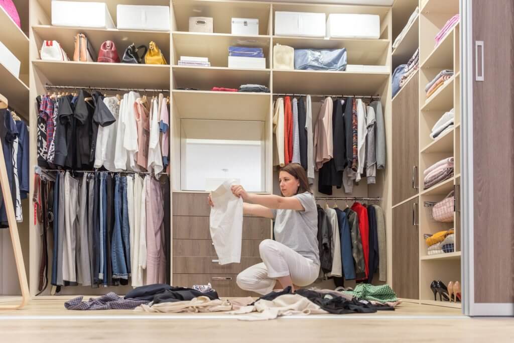 woman looking at clothing in her closet