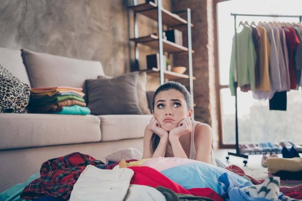 unhappy woman surrounded by clothing