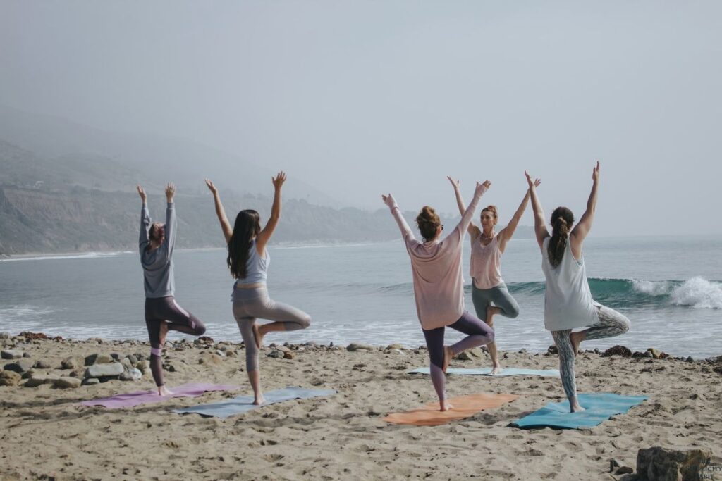 people stretching outside with mats