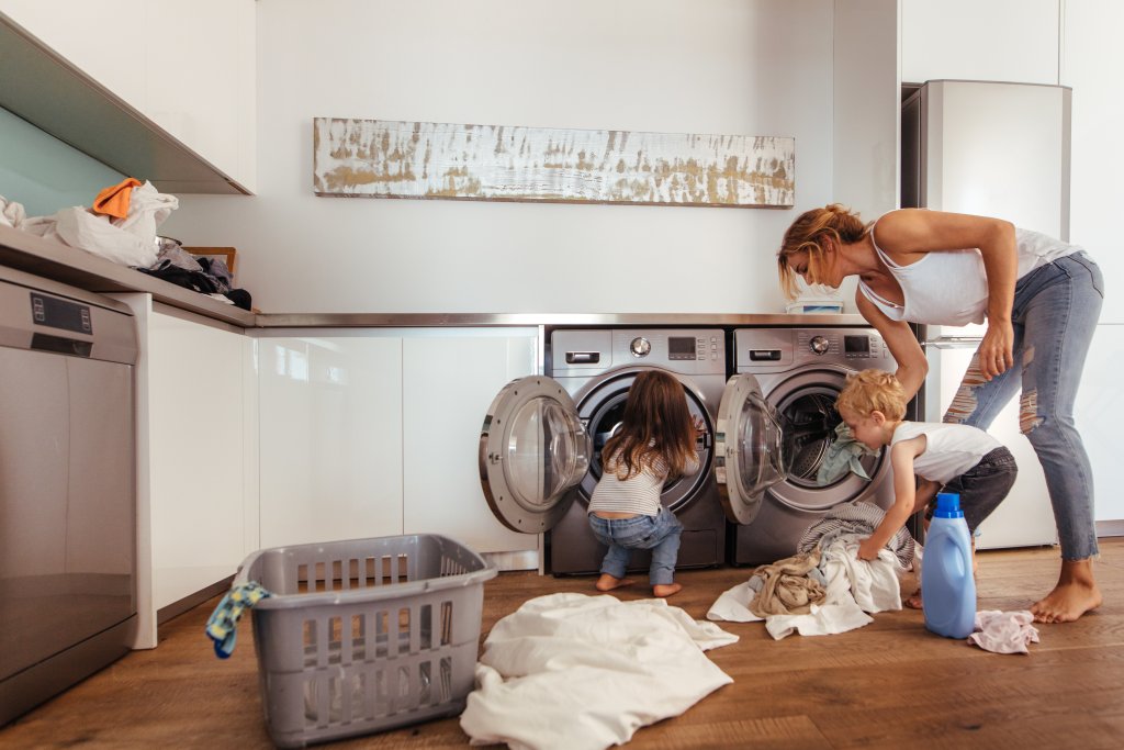 mom doing laundry with her children