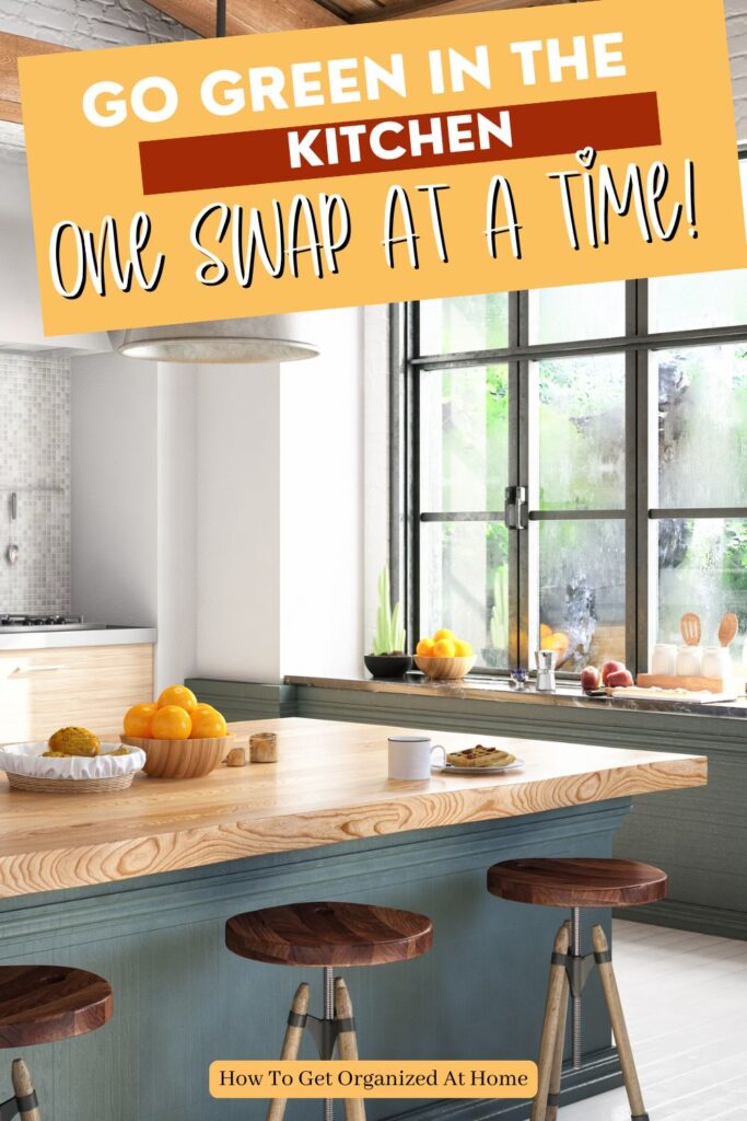 the words ‘Go Green in the Kitchen 🍃 One Swap at a Time’ are on the image of a kitchen with minimal items, a wooden island and benches underneath.