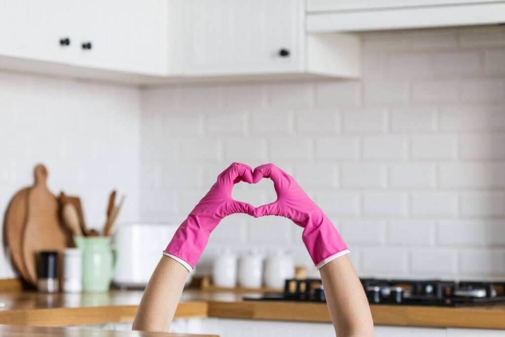 gloved hands forming a heart in the kitchen
