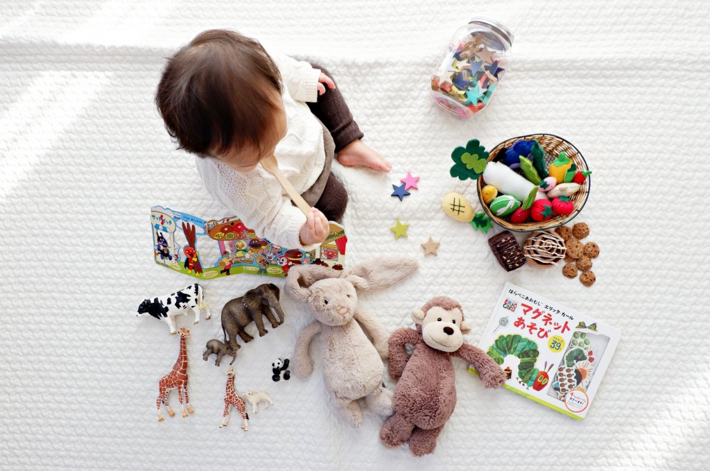 child sitting with toys surrounding him
